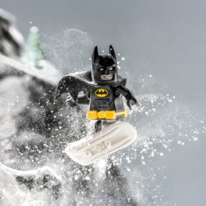 Минифигурка Бэтмена LEGO на сноуборде среди снежных брызг