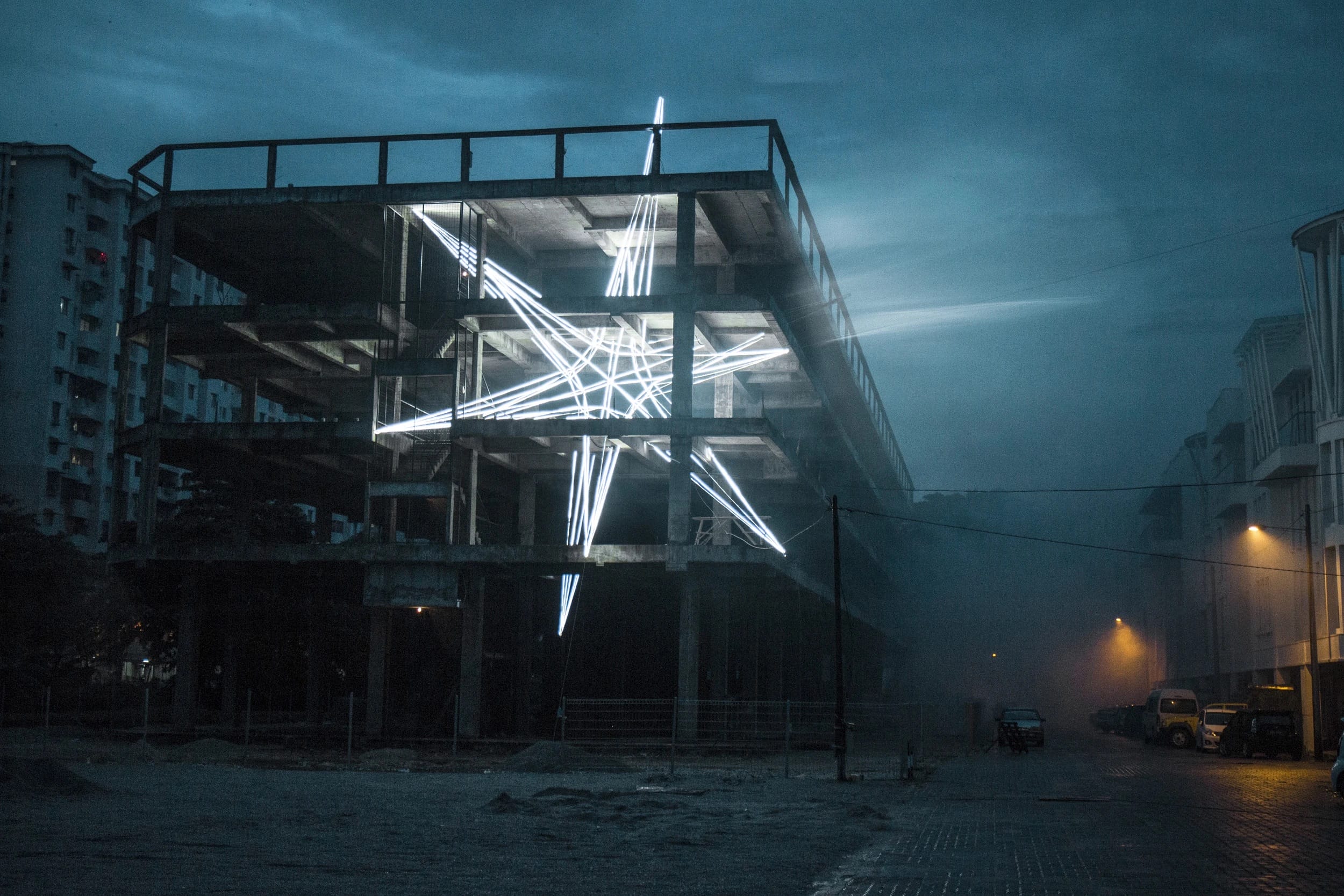 Световая звезда STAR/BUTTERWORTH в бетонном каркасе здания ночью
