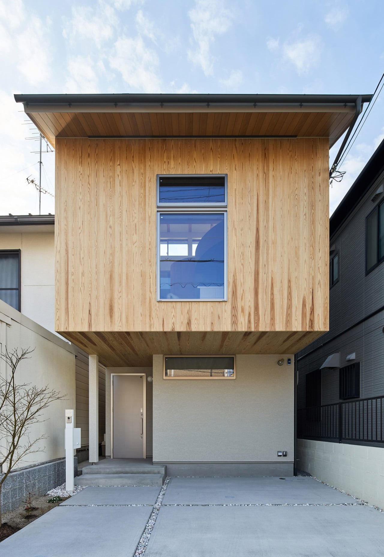 Деревянный фасад Sugi House с утопленным входом и парковкой